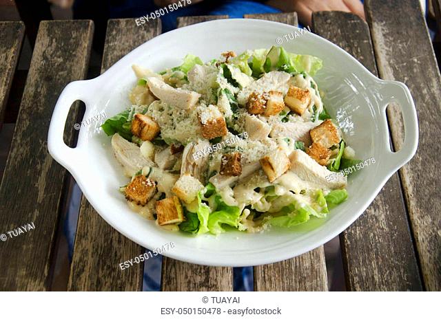 Caesar salad with chicken with biscuits on wooden table in restaurant at Tak, Thailand