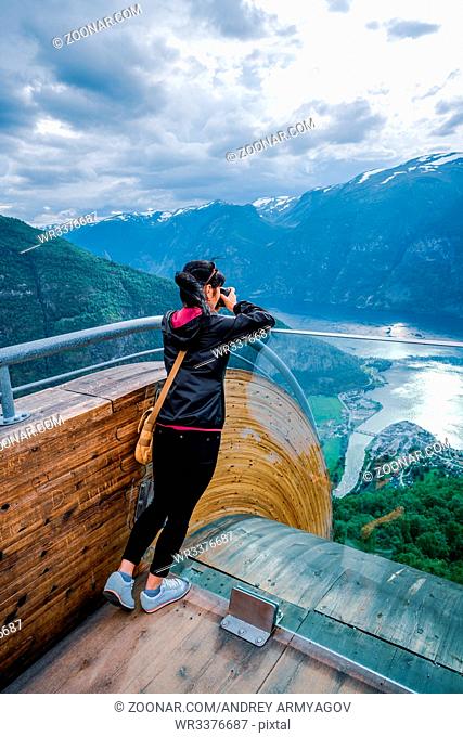 Nature photographer tourist with camera shoots. Stegastein Lookout. Beautiful Nature Norway