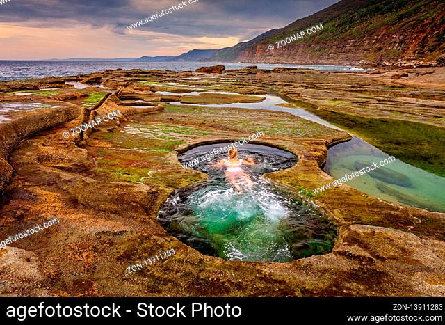 A woman enjoying a swim in the Figure 8 plunge pools. A set of rock pools located on the rock shelf exposed in low tide only