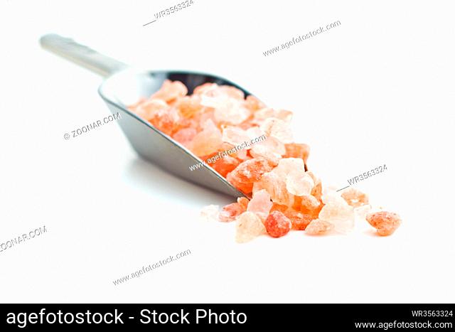 Pink himalayan salt in scoop isolated on white background
