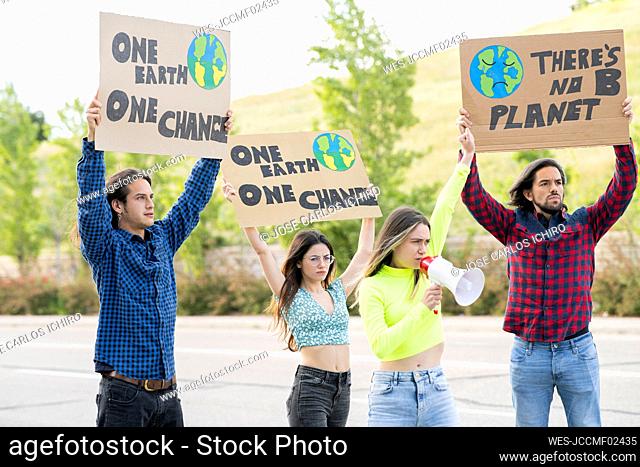 Angry female activist with megaphone announcing while protesting on climate change