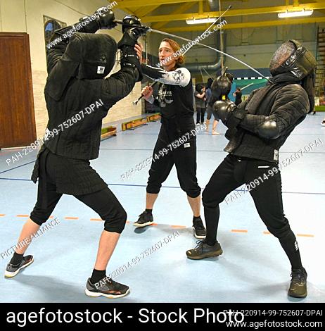 08 September 2022, Saxony, Leipzig: Historical fencing with long swords is practiced in a gymnasium by fencing instructor Torsten Schneyer (2nd from right) with...