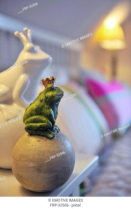 Frog figurine with crown sitting on ball