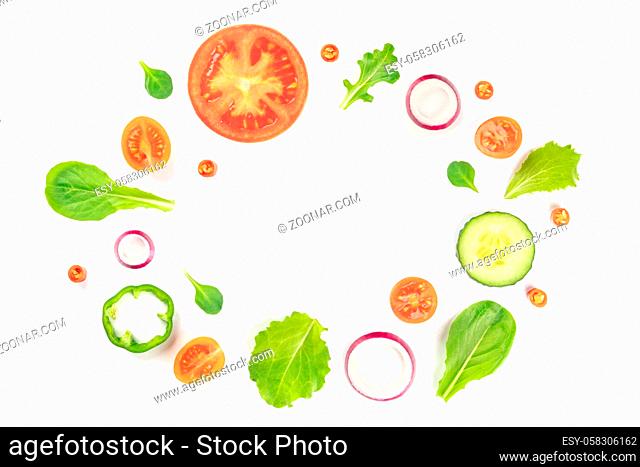 Fresh vegetable salad ingredients, shot from above on a white background. A flat lay composition with tomato, pepper, cucumber, onion slices and mezclun leaves