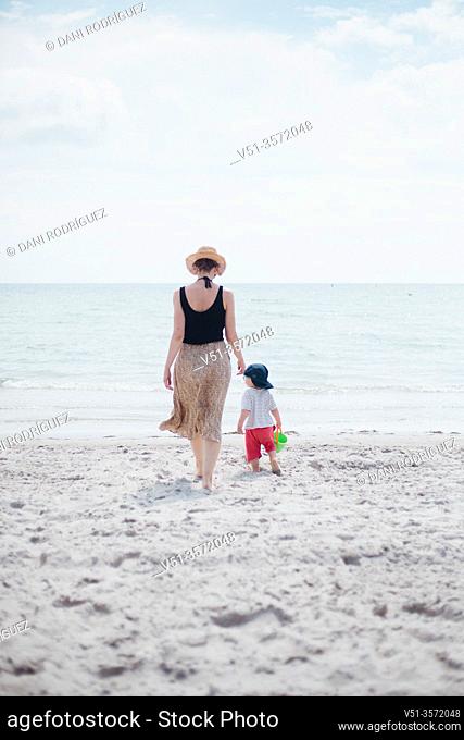 2 years old boy with his mother at the beach