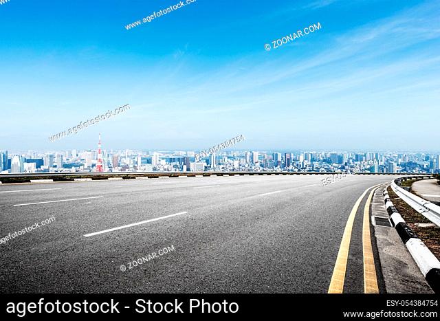empty asphalt road and cityscape of tokyo in blue cloud sky