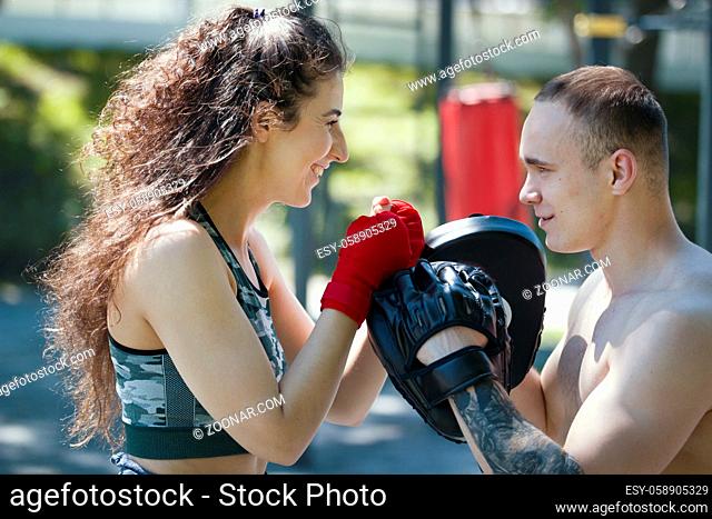 Portrait of young lovely couple looking into each other's eyes in boxing workout, horizontal