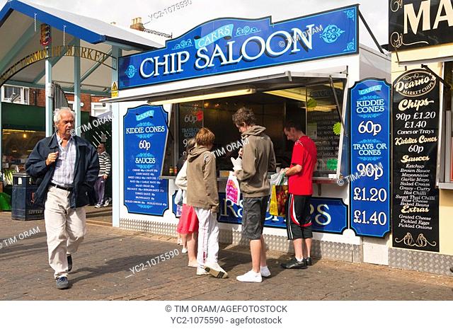 People eating chips from a chip stall at the market in Great Yarmouth , Norfolk , Uk