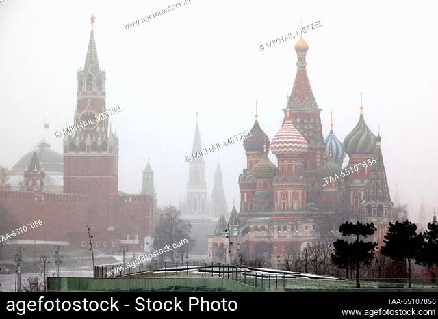 RUSSIA, MOSCOW - NOVEMBER 23, 2023: A view of the Moscow Kremlin's Spasskaya Tower and St Basil's Cathedral during a snowfall. Mikhail Metzel/TASS