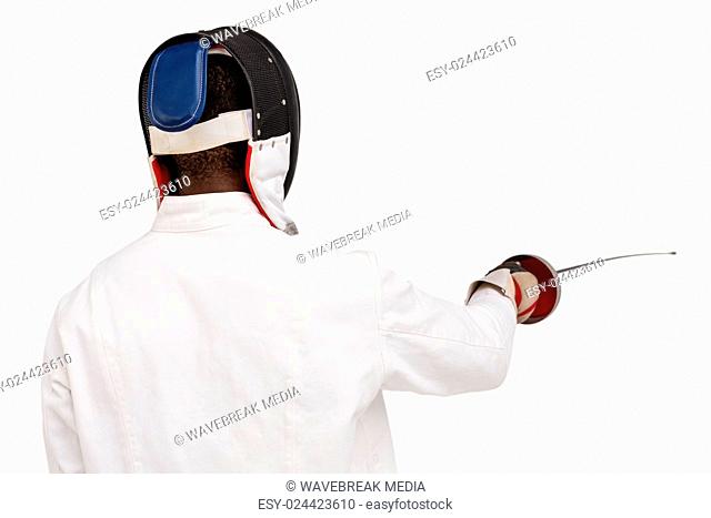 Rear view of man wearing fencing suit practicing with sword