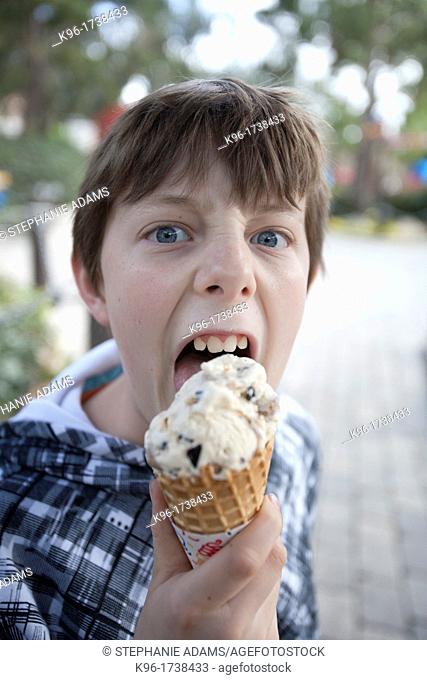 boy looking unhappy eating an ice cream cone