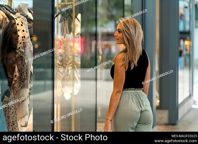 Woman doing window shopping while standing by store window