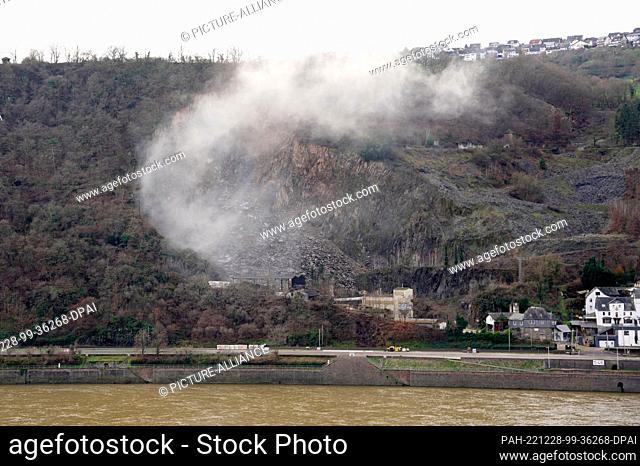 28 December 2022, Rhineland-Palatinate, Oberwesel: A cloud of dust can be seen above a slope after a blasting of rock. Emergency workers are using a blasting...