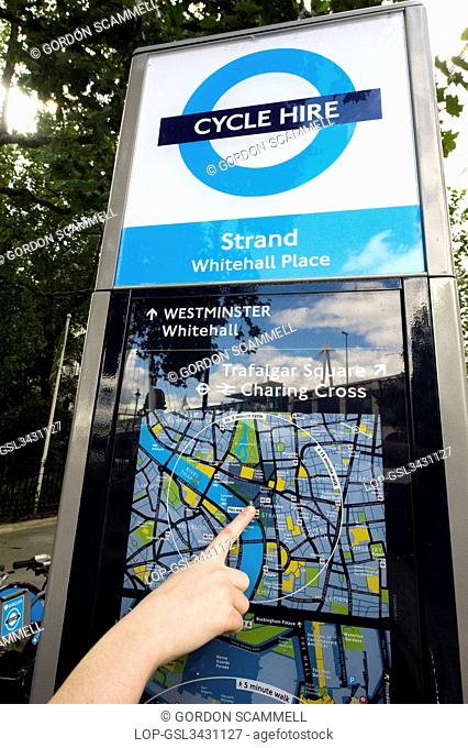 England, London, Westminster. Close-up of a persons hand pointing out their location on a map at a terminal of a Barclays Cycle Hire docking station