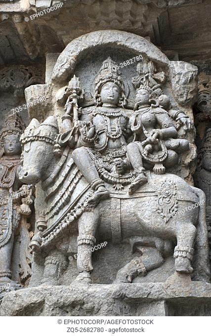 Ornate wall panel reliefs depicting Shiva-Parvati seated on Nandi, Kedareshwara temple, Halebidu, Karnataka, india