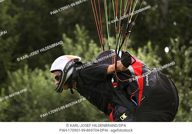 A pupil of the paragliding school during their examination flight near Schwangau, Germany, 30 July 2017. Photo: Karl-Josef Hildenbrand/dpa