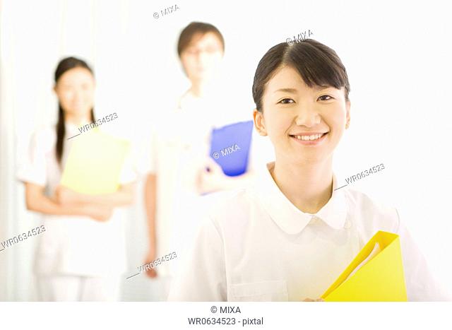 Female nurse smiling and holding file