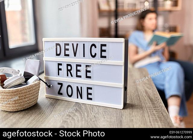 gadgets at device free zone and woman reading book