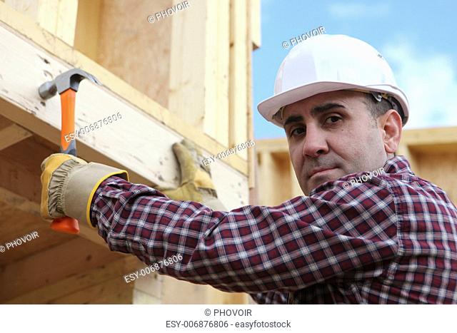 Man erecting wooden house