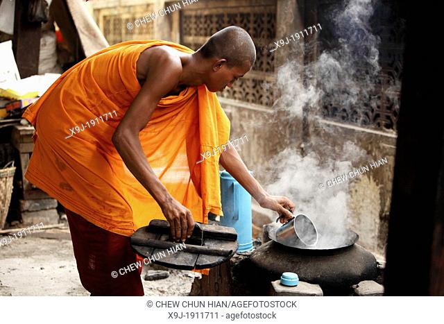Monk at work boiling water, burman novice, Myanmar, Burma, Asia