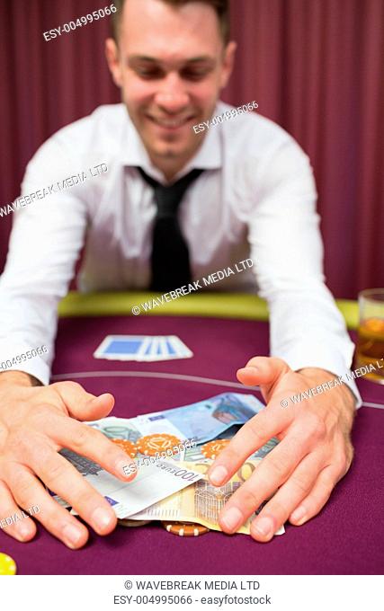 Man sitting at table happy grabbing money