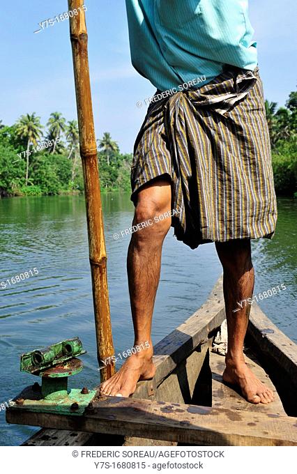 Indian boatman with bamboo pole rowing , close-up, Kerala backwaters, Kerala, South India, Asia