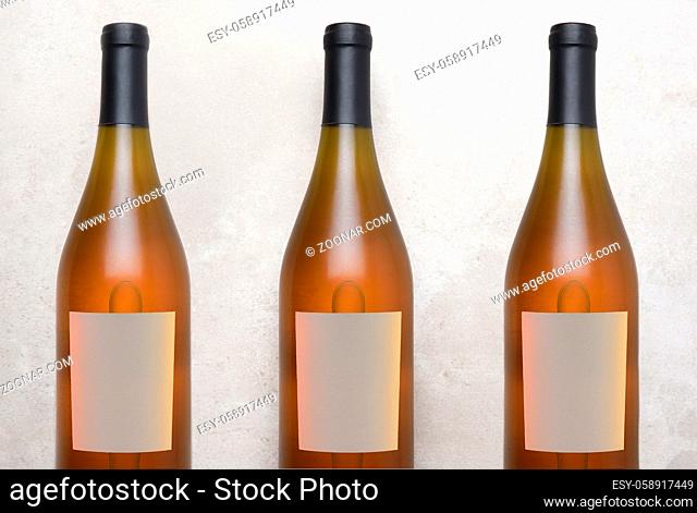 Chardonnay Wine: Top view of a three bottles with blank labels on a concrete counter top