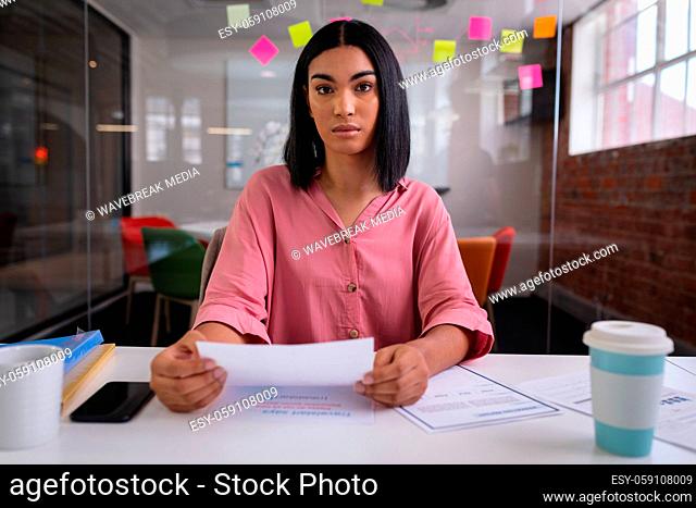 Mixed race businesswoman sitting at desk while having a video call