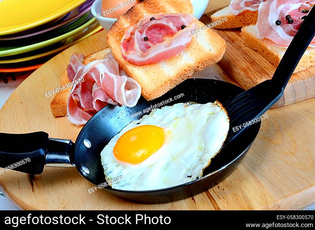 fried egg with bacon and toasted bread