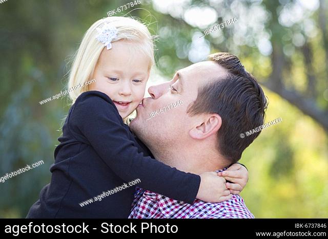 Loving father kissing adorable little girl outdoors