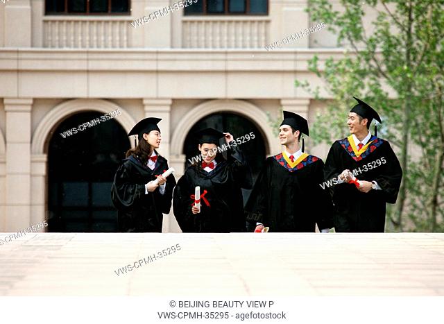 Four university students in graduation gown