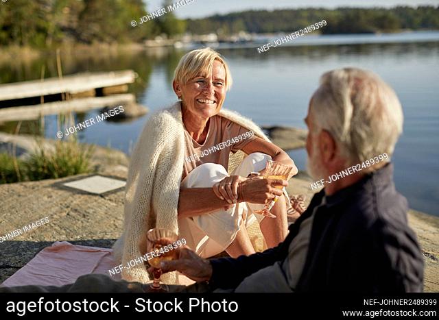Smiling couple having picnic at lake