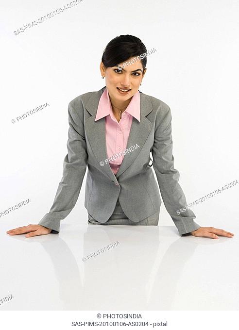 Portrait of a businesswoman leaning on a desk