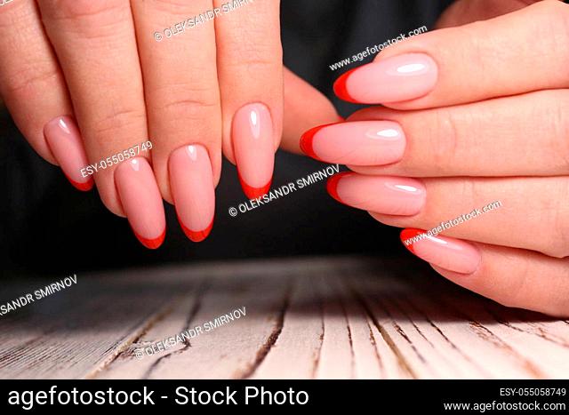 Beautiful groomed woman's hands. Nail varnishing in white color. Manicure, pedicure beauty salon