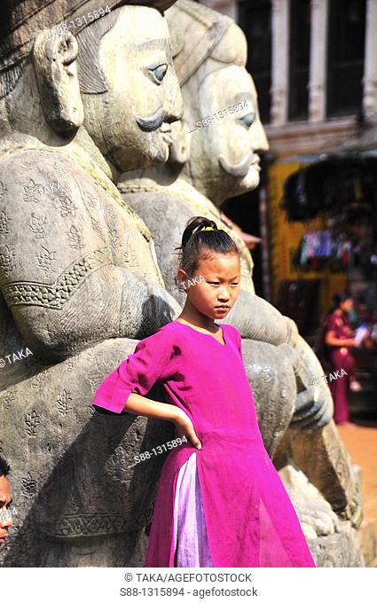 Girl standing by the big stone statue at Nyatapola Temple in Taumadhi Tol square