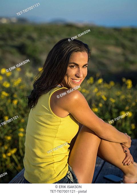 Portrait of women sitting against green meadow