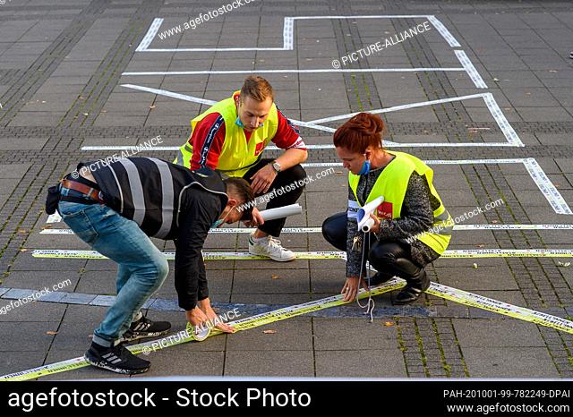 01 October 2020, Saxony-Anhalt, Magdeburg: Verdi workers stick the word ""strike"" on the pavement with adhesive tape in preparation for a rally on the strike...