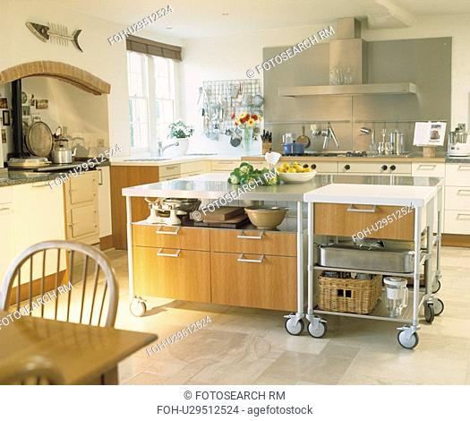 Movable large island unit on castors in modern white kitchen with limestone floor tiles