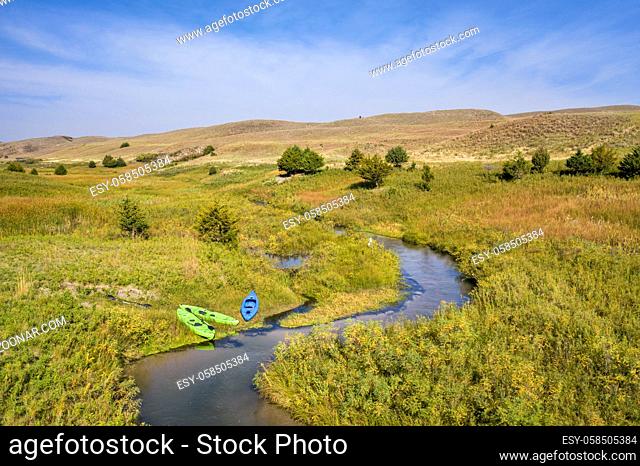 kayaks on the shore of a stream meandering in Nebraska Sandhills - North Fork of Dismal River near Dismal River Golf Club, early fall aerial view