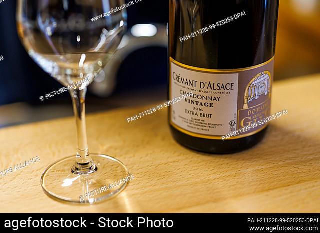 17 December 2021, France, Mittelbergheim: A bottle of Alsace Cremant of the ""Chardonnay Vintage 2016 Extra Brut"" variety is standing on a counter in the...