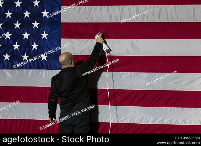 A person steams an American flag before an event with US Vice President Kamala Harris and Marcia Fudge, secretary of Housing and Urban Development (HUD)
