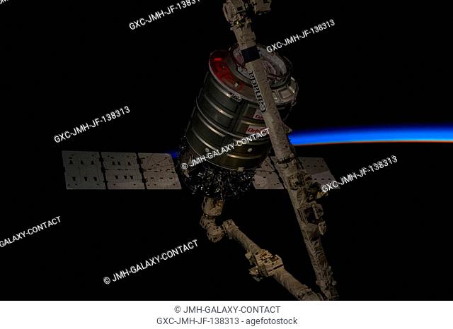 Intersecting the thin line of Earth's atmosphere, the Orbital Sciences Corp. Cygnus commercial cargo craft attached to the end of the Canadarm2 robotic arm of...