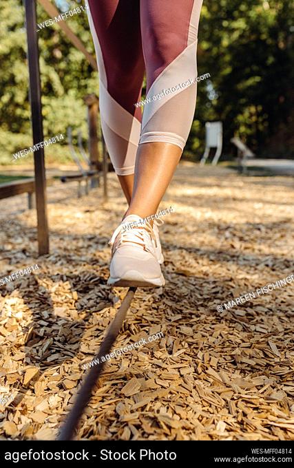 Close-up of woman balancing on rope on a fitness trail
