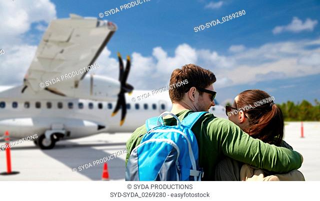 couple of tourists with backpacks over airplane