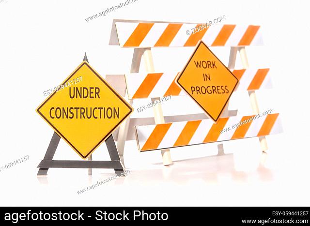 Construction warning barriers with Work in Progress and Under Construction signs over white background