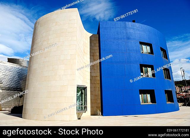 Building next to the Guggenheim Museum in Bilbao photographed in a sky full of clouds on a blue strong