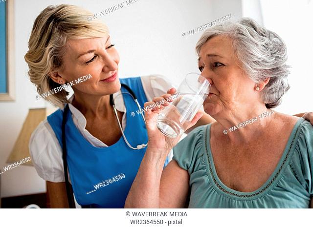 Nurse giving medicaments to a senior woman
