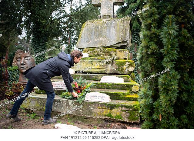 12 December 2019, Baden-Wuerttemberg, Mannheim: Alexander Tanzer places a flower arrangement on the tomb at Mannheim's main cemetery
