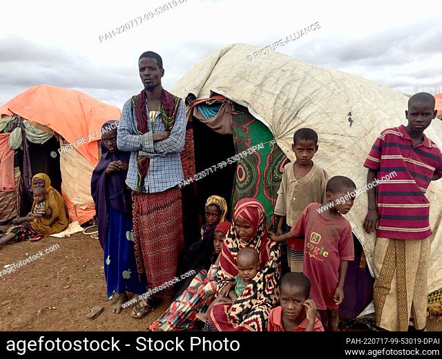 28 June 2022, Somalia, Baidoa: Here are first pictures of Ali Nur, his wife Salado (M, below), taken with their children in front of the family's makeshift hut