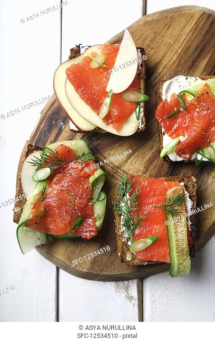 Danish traditional snack smorrebrod with salmon, cucumbers and cream cheese